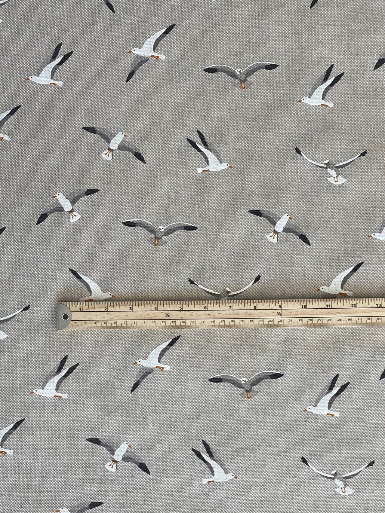 Seagulls patterned fabric with a ruler for scale on a gray background