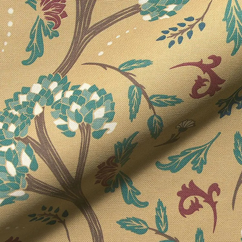 Close-up of Golden Cypress cotton blend fabric featuring intricate botanical and foliage print in teal, burgundy, and ivory on a warm mustard yellow background — ideal for upholstery, curtain panels, Roman shades, and rustic or bohemian home decor projects