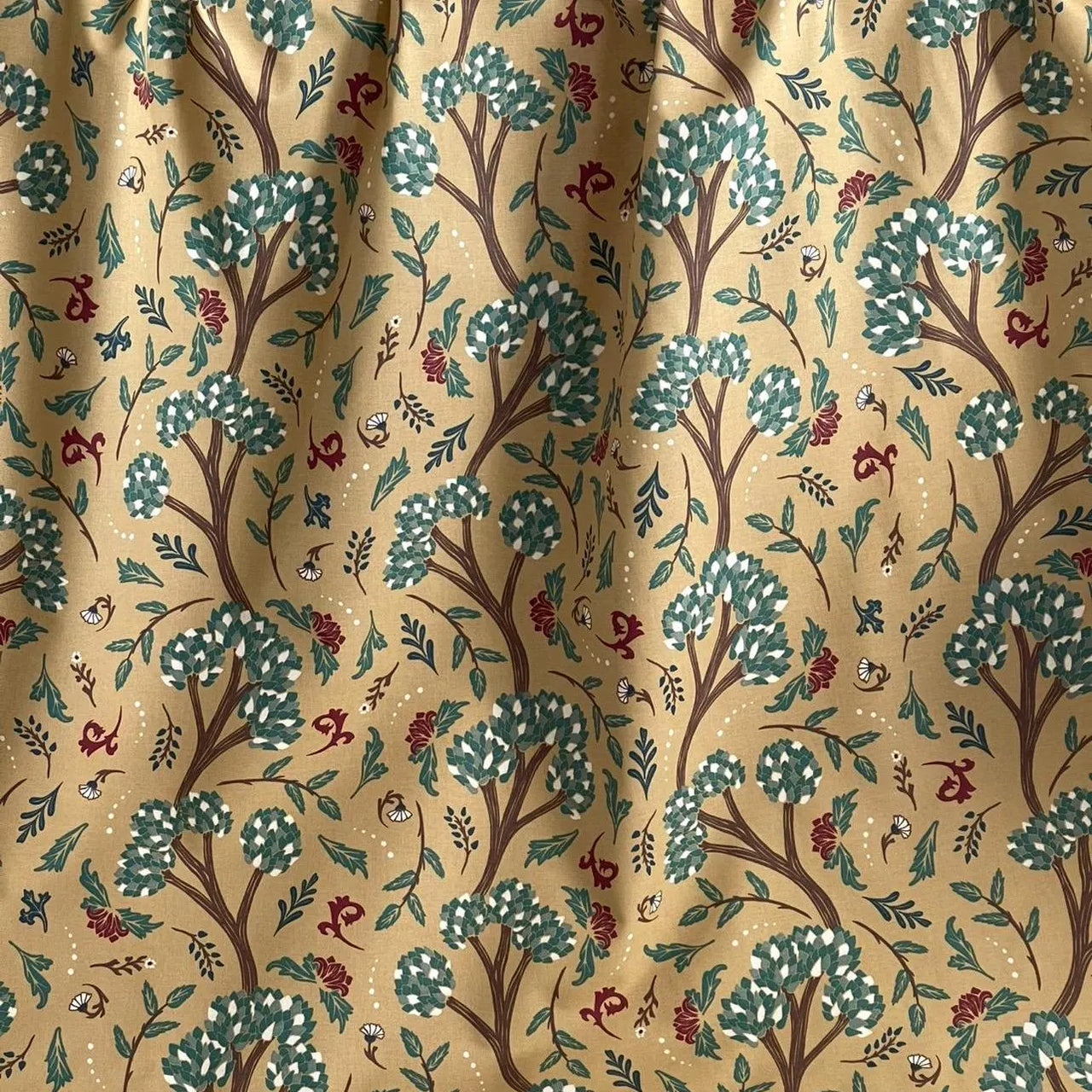 Golden Cypress cotton blend fabric shown as a gathered curtain, featuring a botanical tree print in sage green, burgundy, and ivory on a rich mustard yellow background — perfect for custom drapery, Roman shades, and boho home furnishings