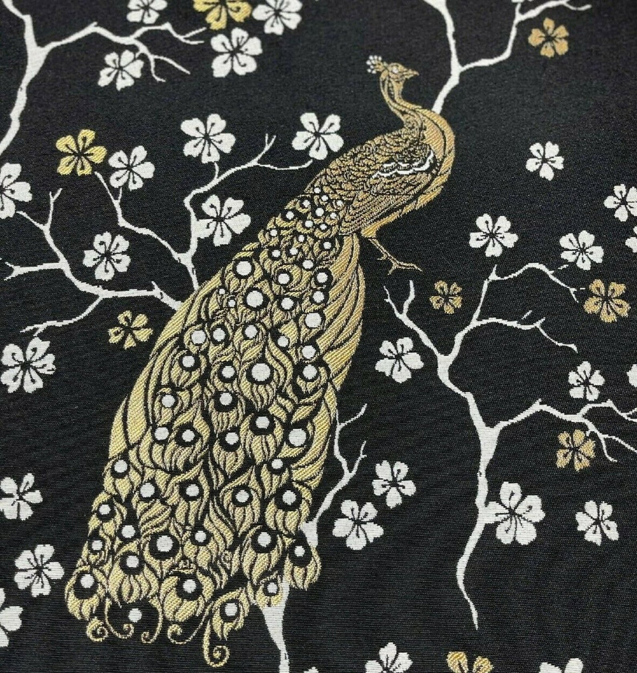 Embroidered peacock design on a black fabric with floral patterns