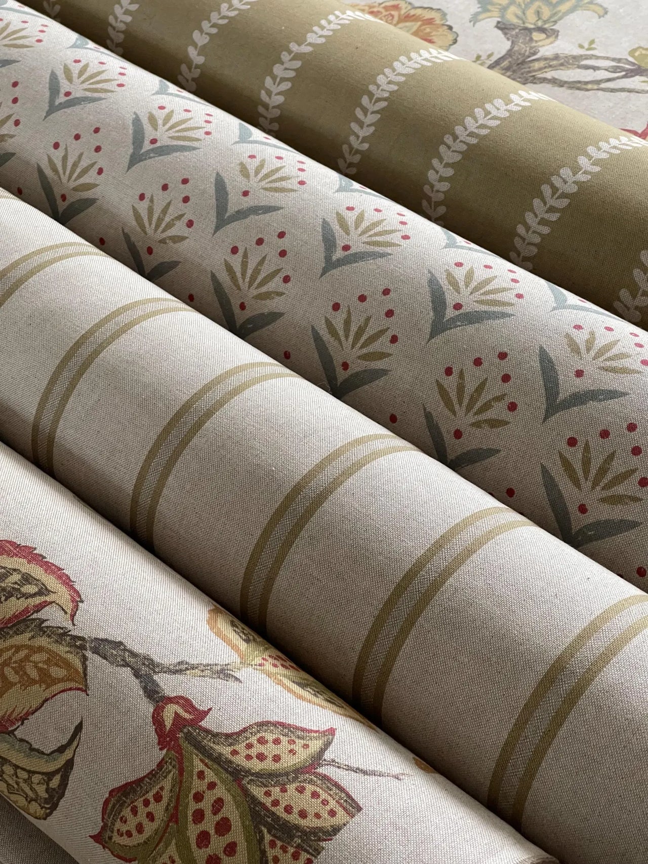 Three rolls of fabric with different patterns stacked on top of each other.