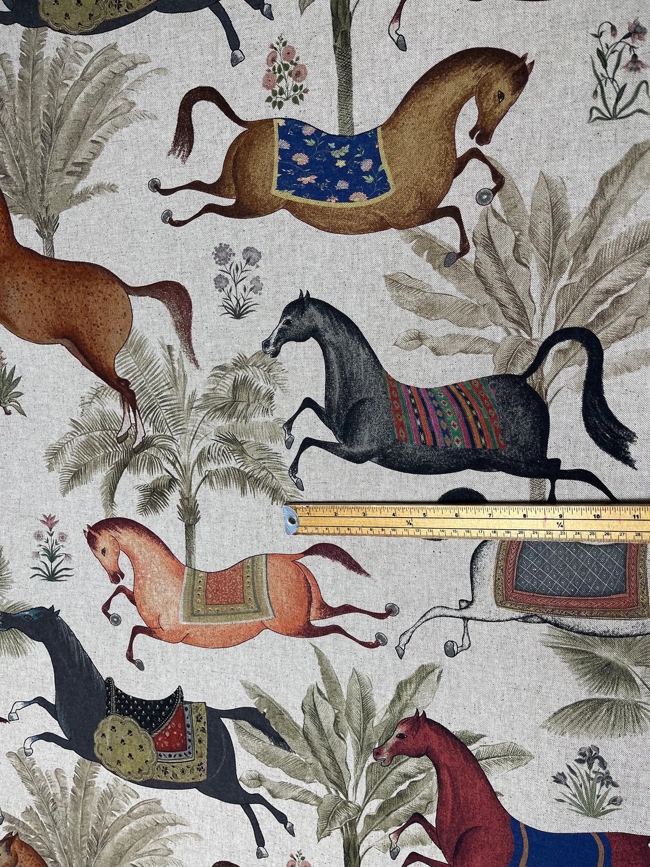 Fabric with horse pattern and a ruler for scale