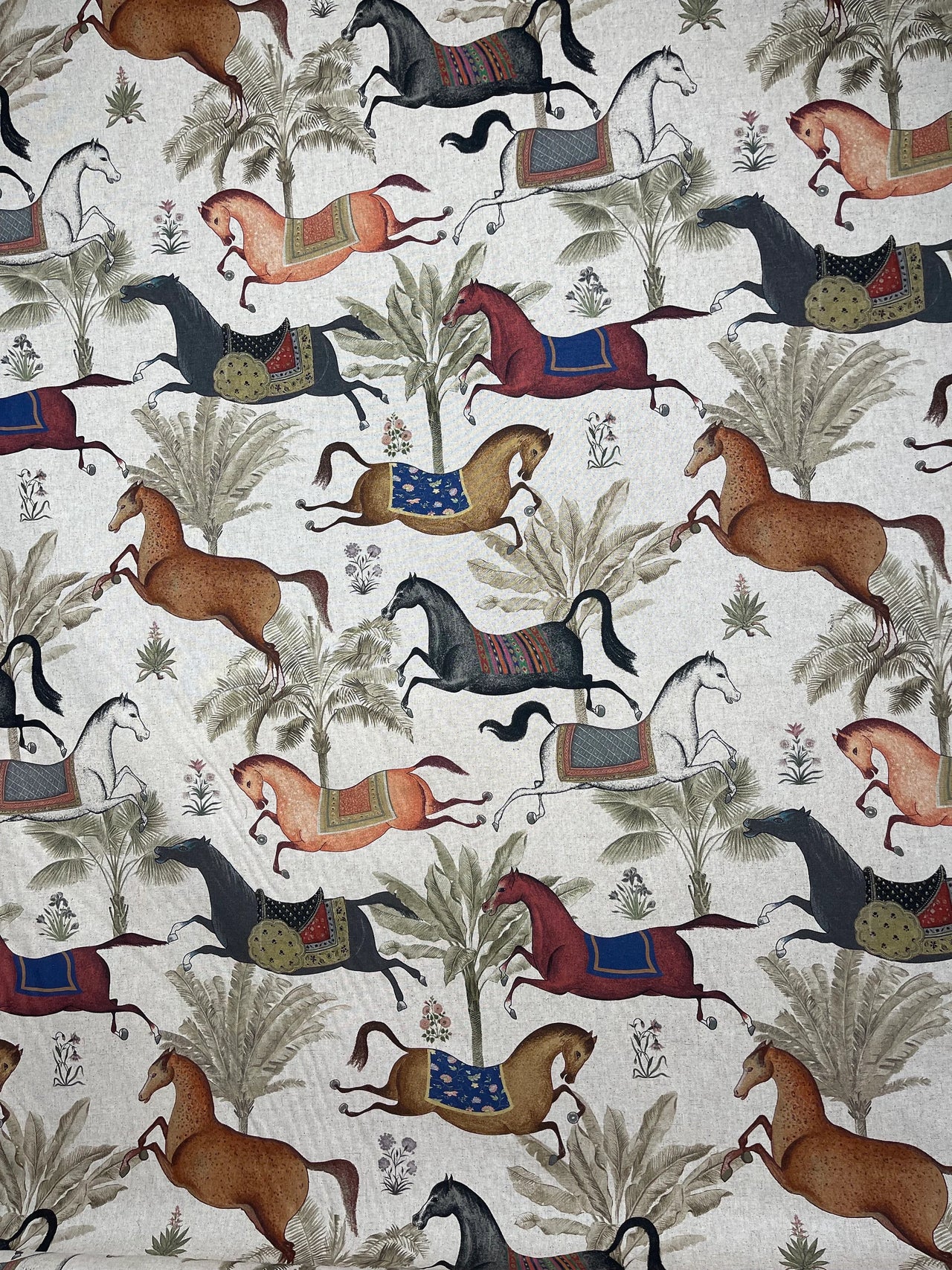 Patterned fabric with horses and trees on a beige background