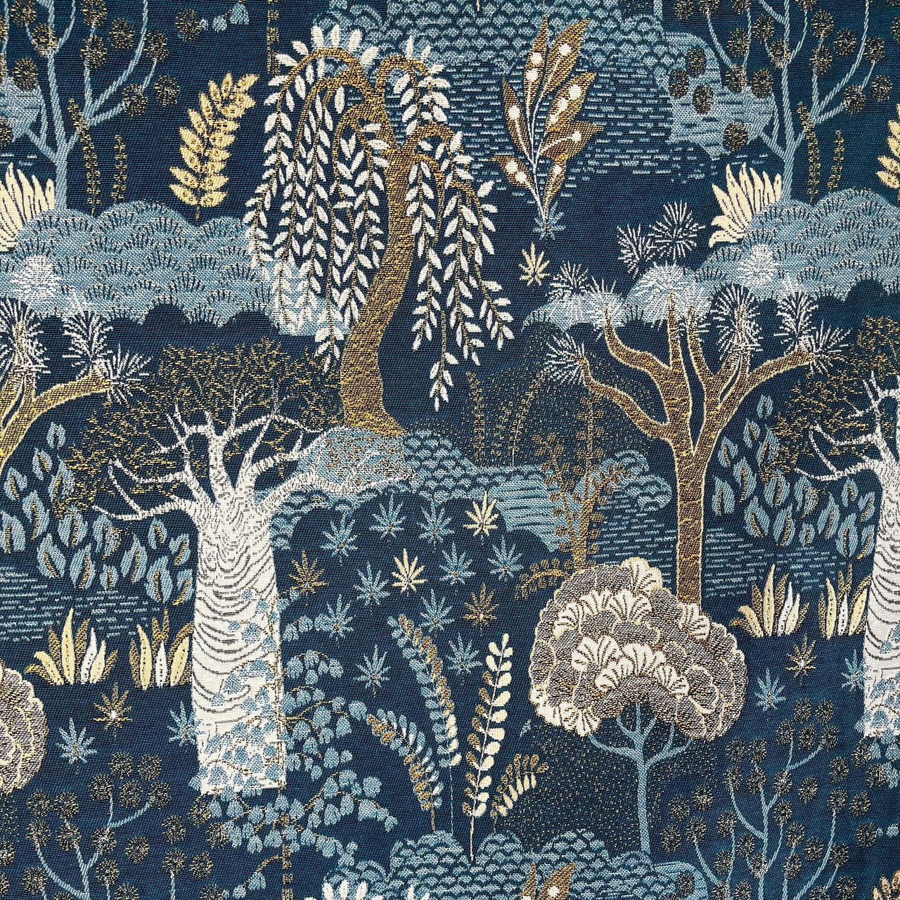 Full view of Baobab Tree of Life tapestry fabric with repeating stylized forest design in blue and gold