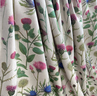 Thumbnail for Draped cotton-linen fabric with botanical Scottish thistle and eryngium print in pink, blue, and green on a neutral background.