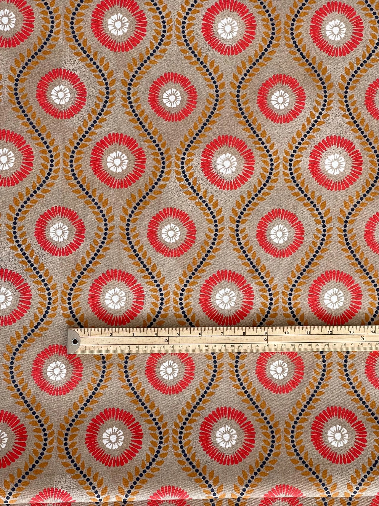 measuring ruler on retro flower print fabric with curved leaf stripes in red mustard and cream for drapery upholstery or roman blinds

