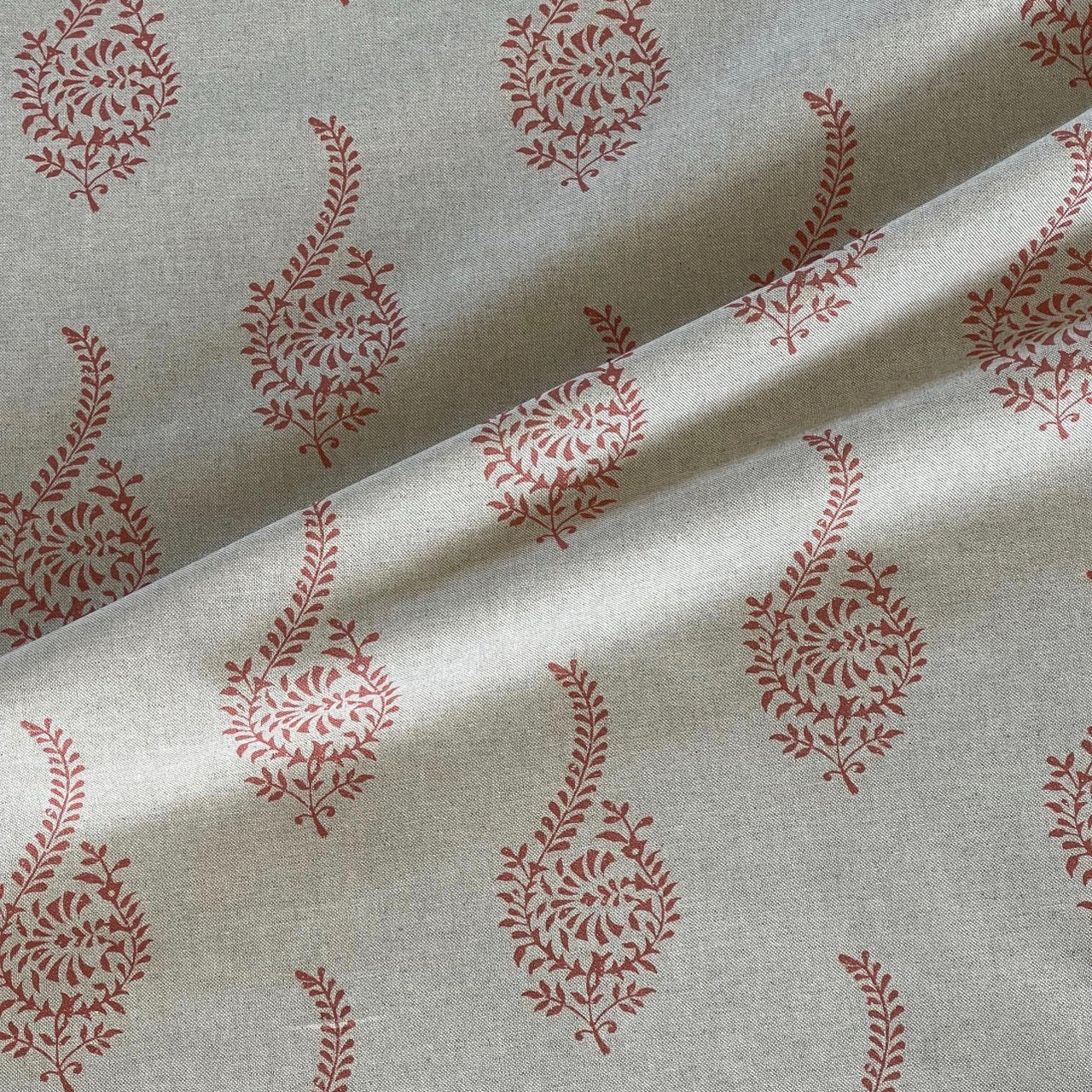 Indian coral paisley buta fabric with botanical sprig pattern on a natural beige background