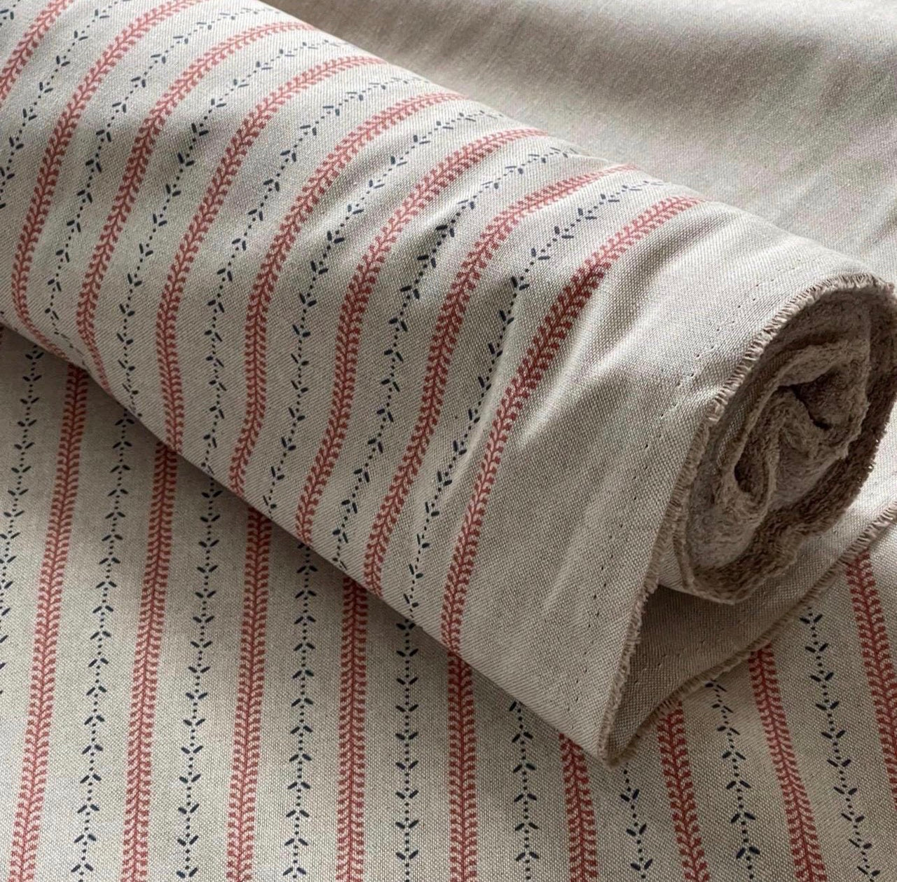 Indigo red botanical stripe cotton linen fabric roll with natural beige background