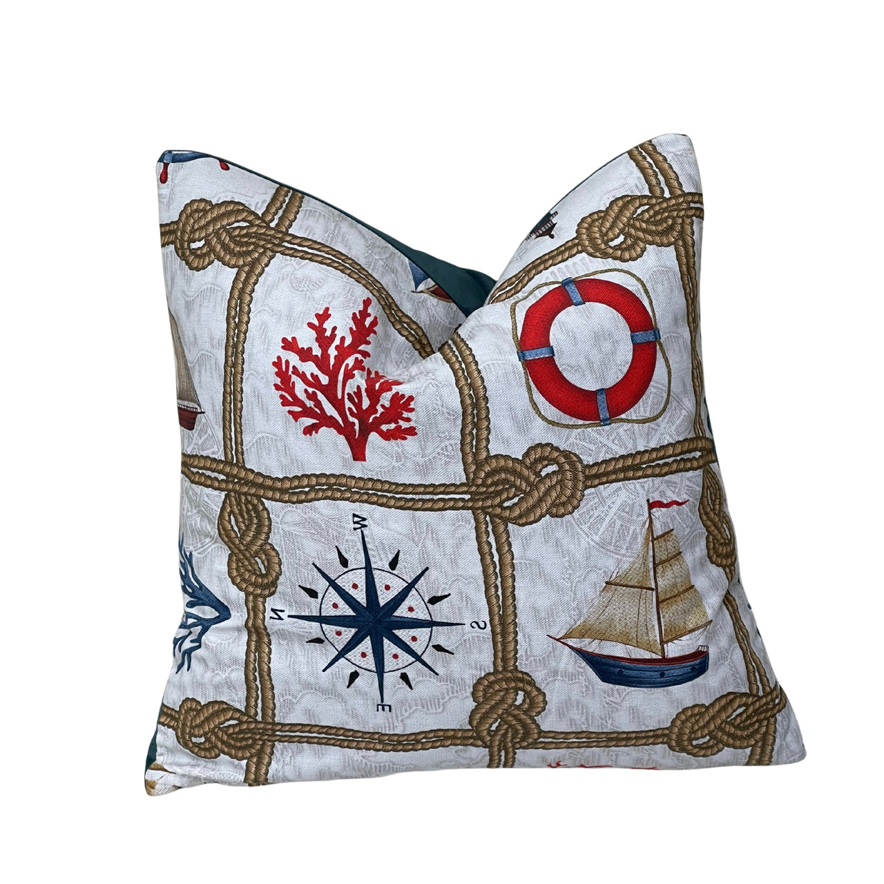 Coastal cotton cushion cover with decorative sailor rope knots, vintage sailing boats, compass rose and red lifebuoy on a pale natural background.