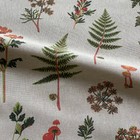 Thumbnail for Close-up of medium-weight botanical furnishing fabric showing its woven texture and printed green and orange woodland design.