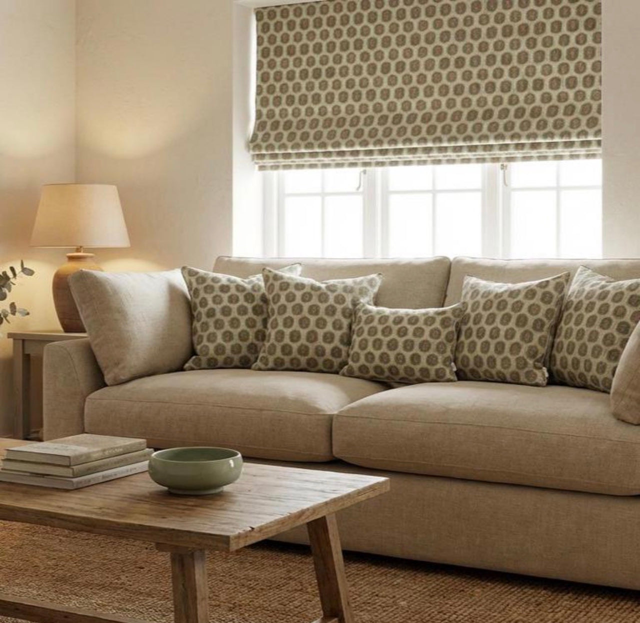 Olive leaf trellis cushions with a matching Roman blind in a neutral living room