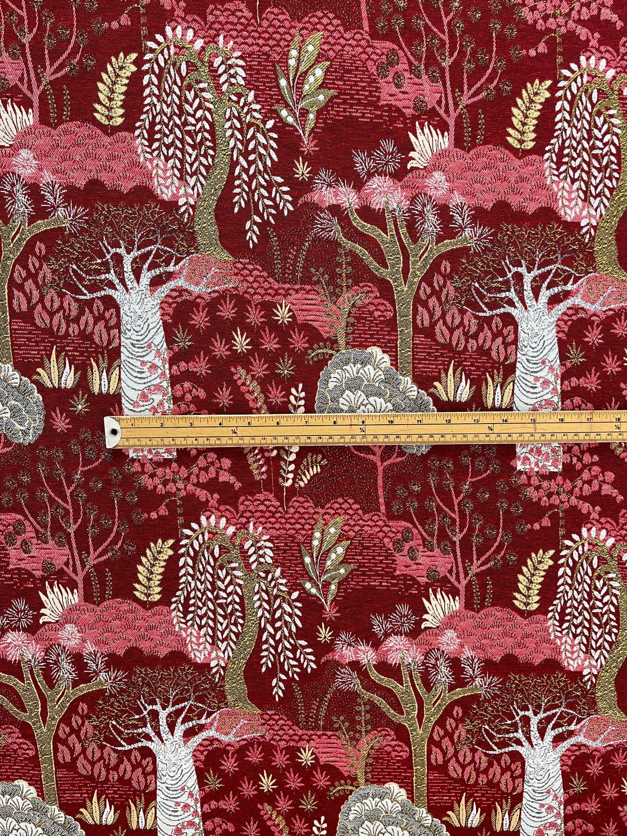 Festive fabric with a red background and white floral patterns, featuring a ruler for scale.