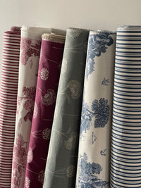 Thumbnail for Rolls of fabric with various patterns arranged against a neutral background