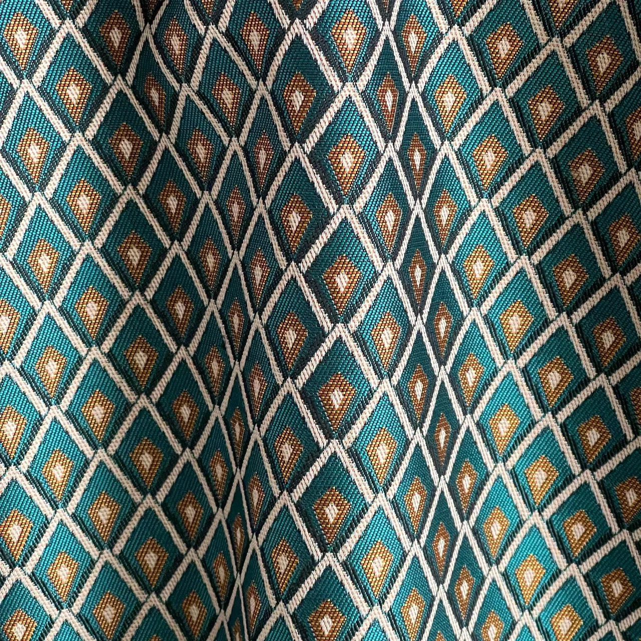 Rosetta Lattice Weave drapery fabric in teal blue and gold geometric pattern, woven cotton blend curtain fabric with elegant lattice design.