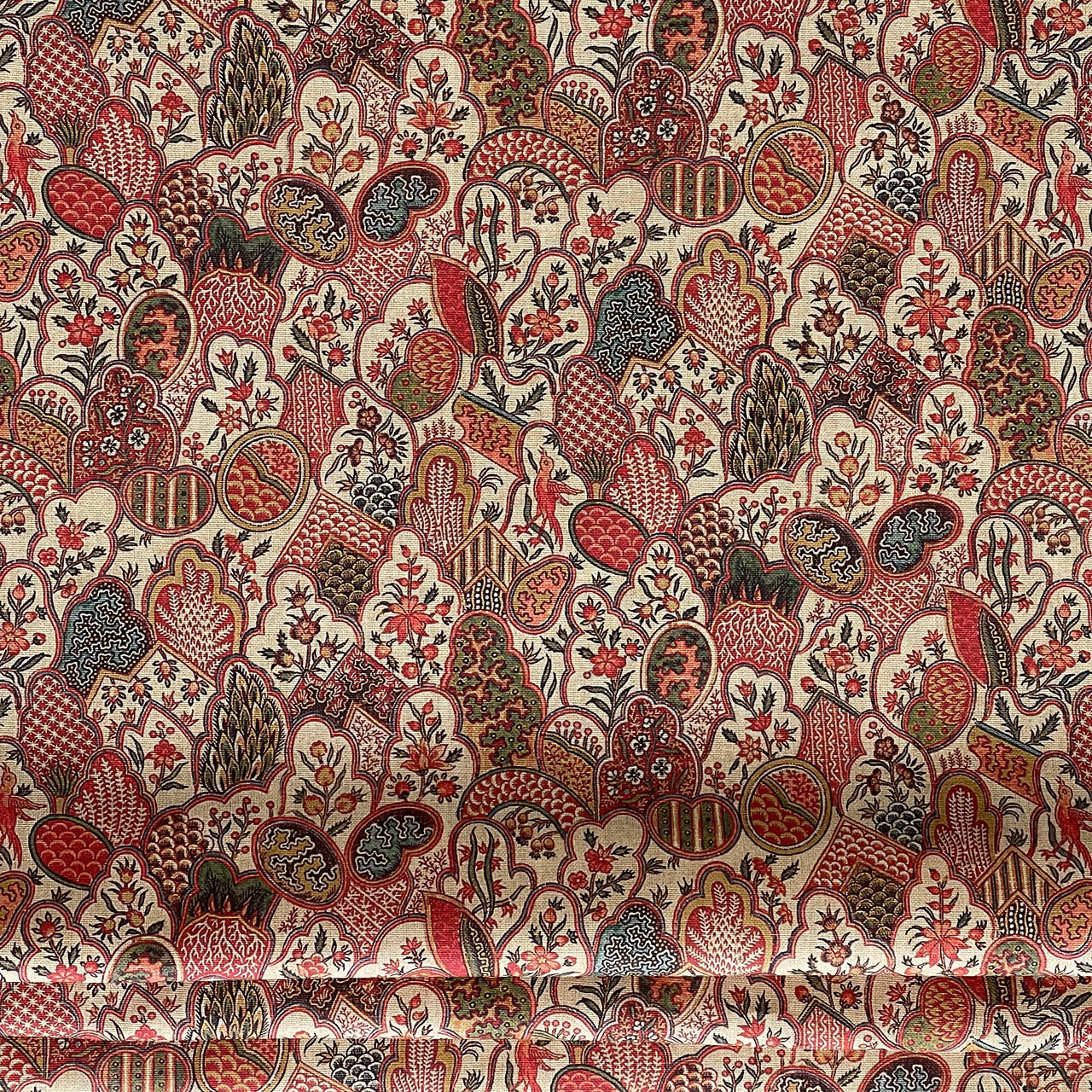 Traditional floral upholstery fabric in rich warm tones laid out in full view