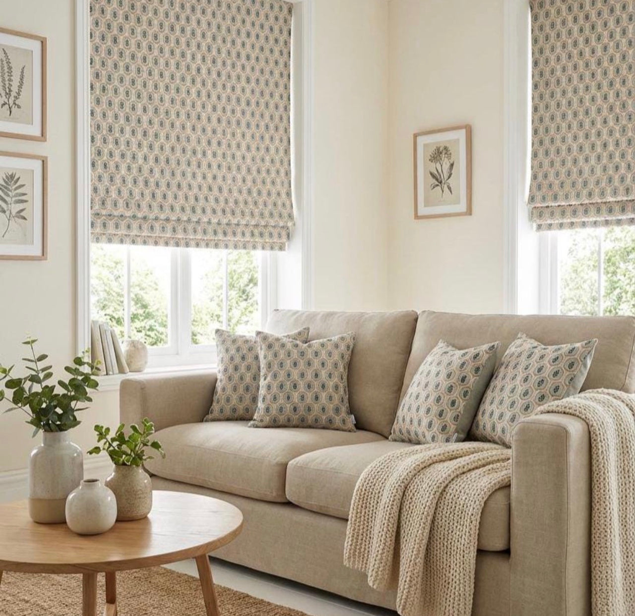 Sage and rust botanical cushion covers styled on a neutral sofa with matching Roman blinds