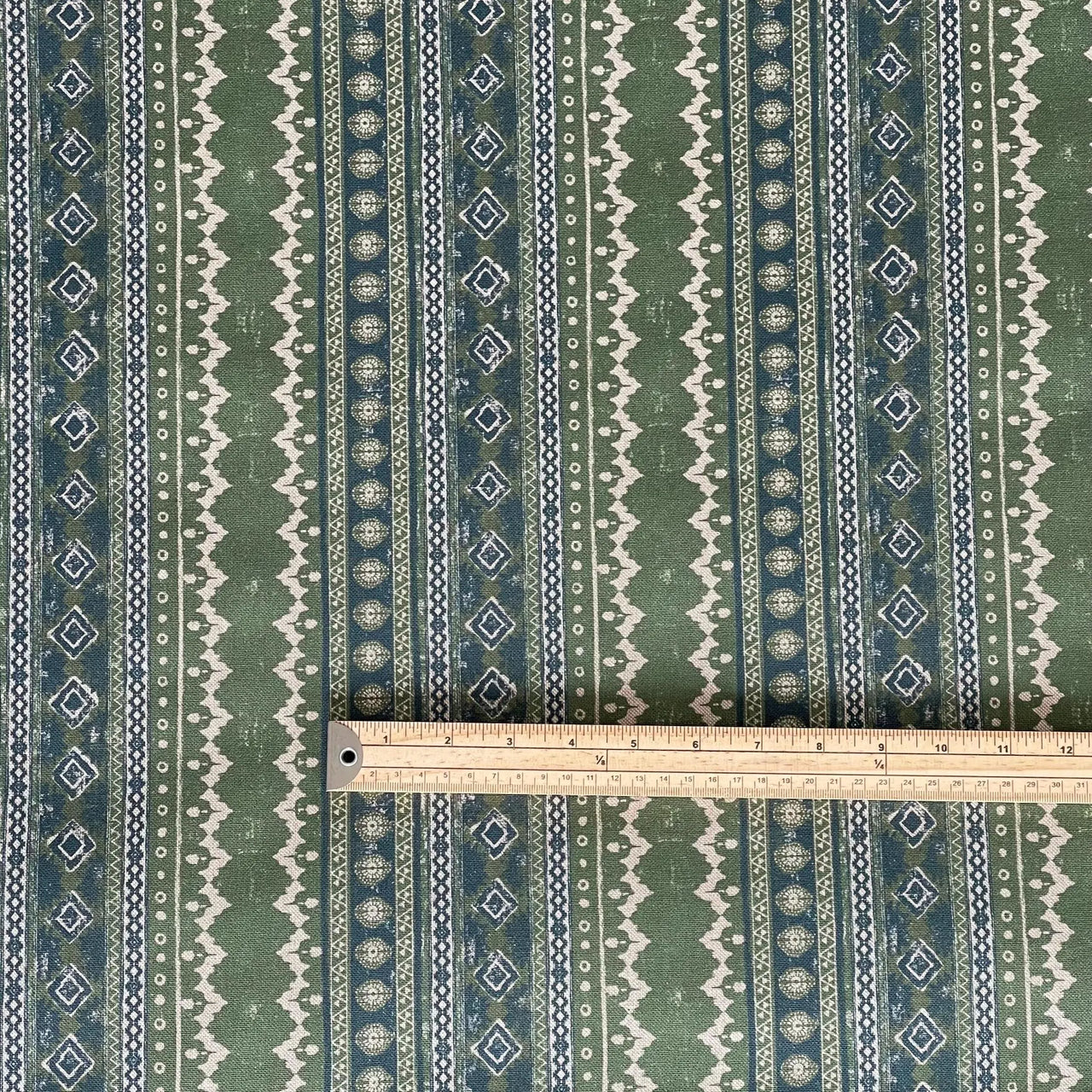 Sage Country fabric with green and blue folk-inspired stripes and geometric detailing, shown with measuring scale – suitable for blinds, soft furnishings, and interior textiles