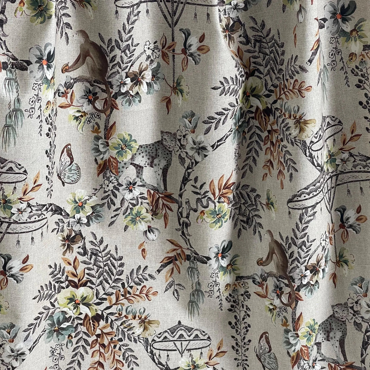Gathered Savannah print fabric with detailed jungle scenes including leopards, monkeys, and wild foliage — excellent for relaxed drapery and exotic decor.