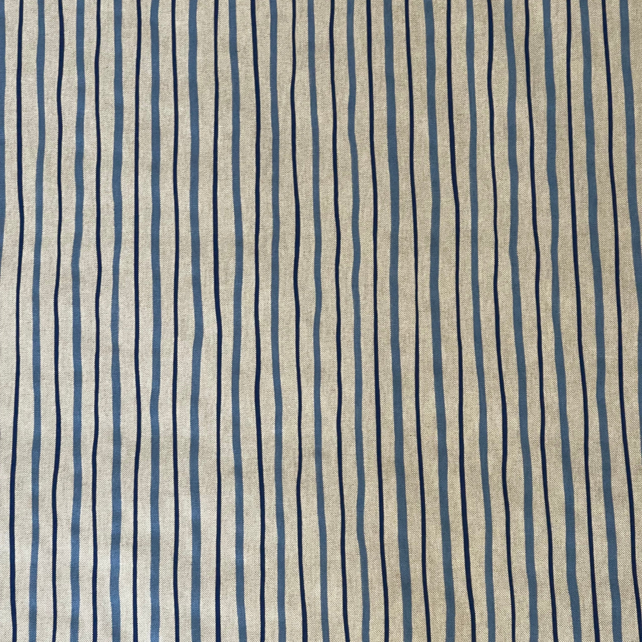 Irregular navy and blue vertical stripe pattern on a natural beige background