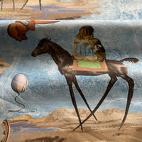Thumbnail for Artistic blue cotton furnishing fabric featuring surrealist elephants, camels, horses and dreamlike landscape illustrations in soft blue and earthy tones.