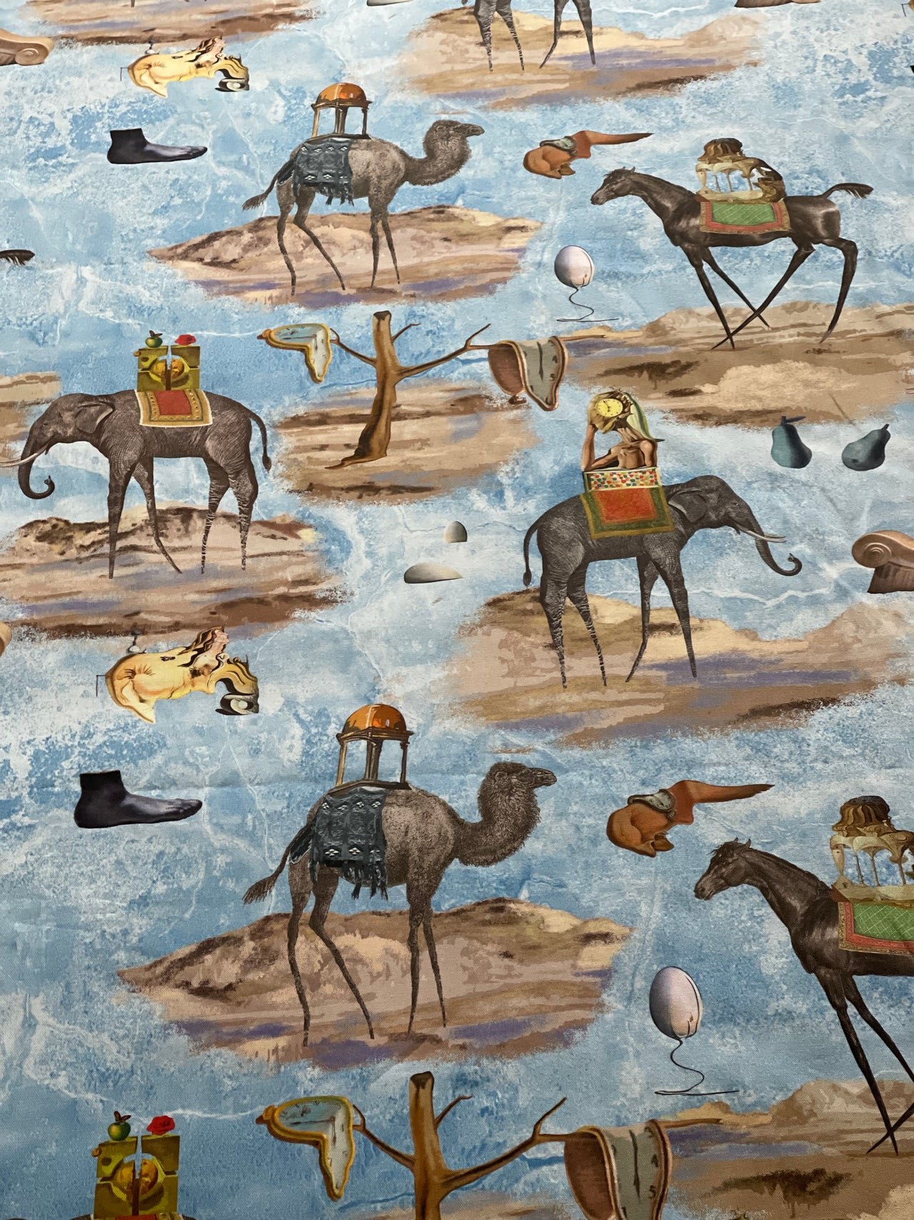 Surrealist blue cotton fabric arranged in soft folds, displaying its animal print and decorative pattern for home furnishing projects.