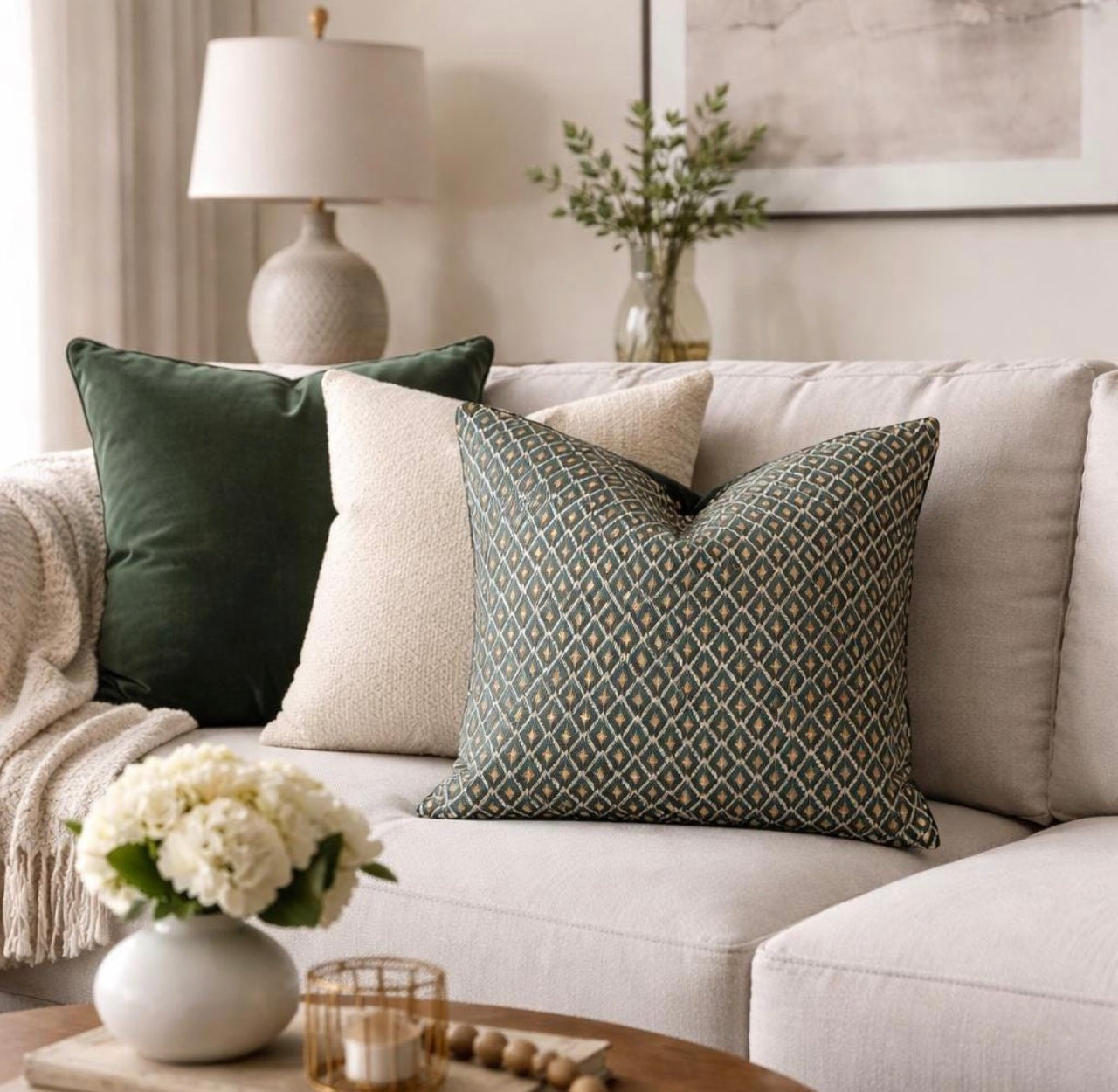 Teal blue and gold geometric cushion styled on a neutral beige sofa