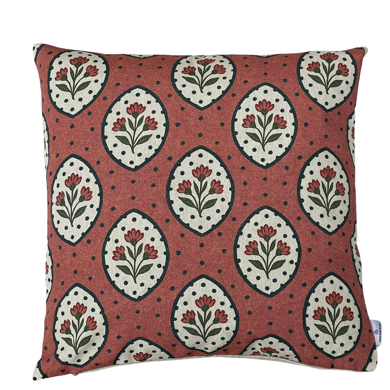Terracotta rosewood decorative cushion cover with repeating cream floral medallions, small red wildflowers, green leaves and dark dotted details on textured cotton fabric