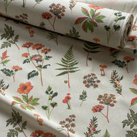 Thumbnail for Botanical meadow fabric featuring orange flowers, fern leaves, mushrooms and scattered green leafy sprigs.