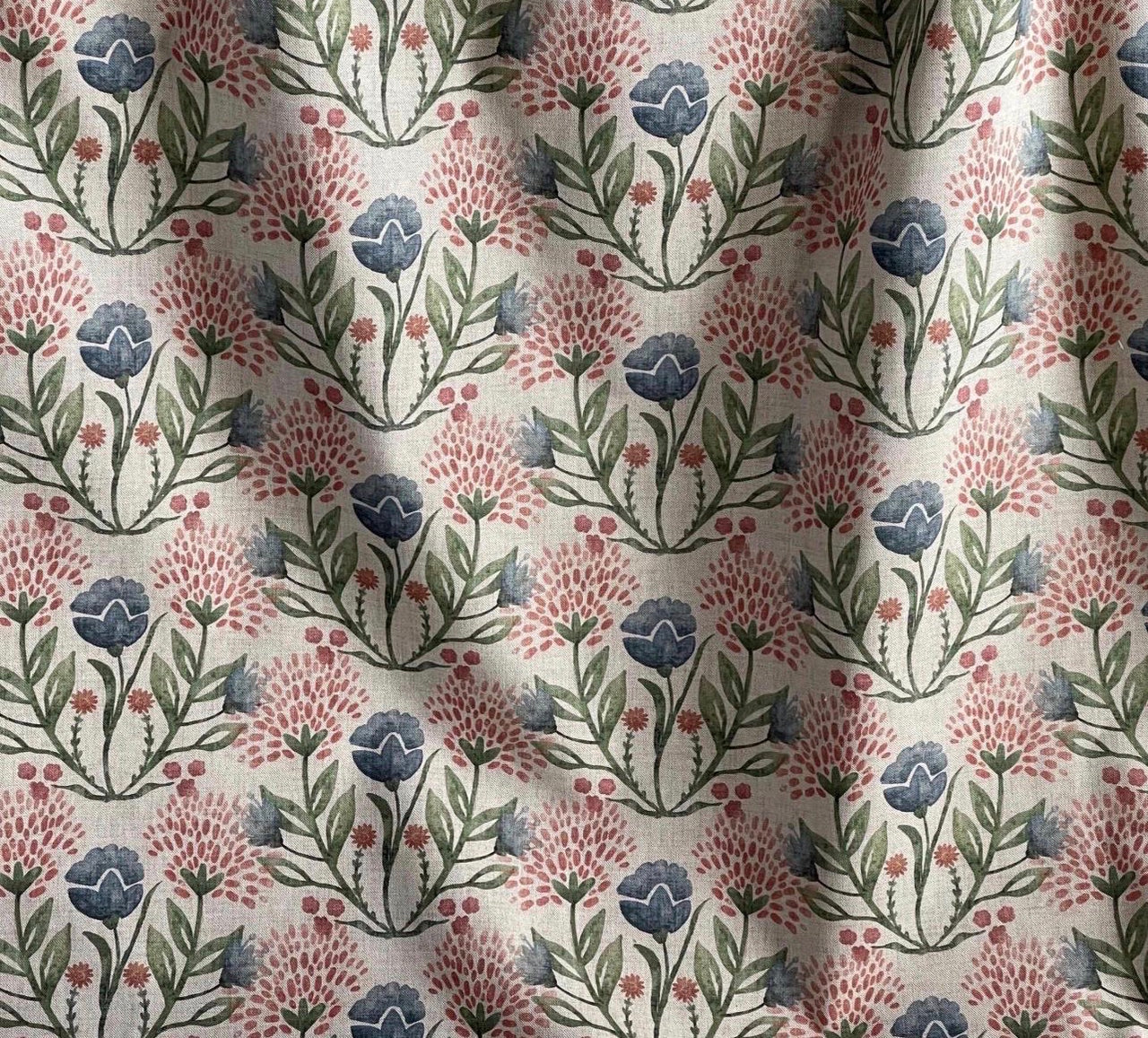 Blue, blush pink and damson meadow flowers with green leaves on natural fabric