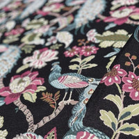 Thumbnail for Close-up of floral and bird patterned fabric on a black background